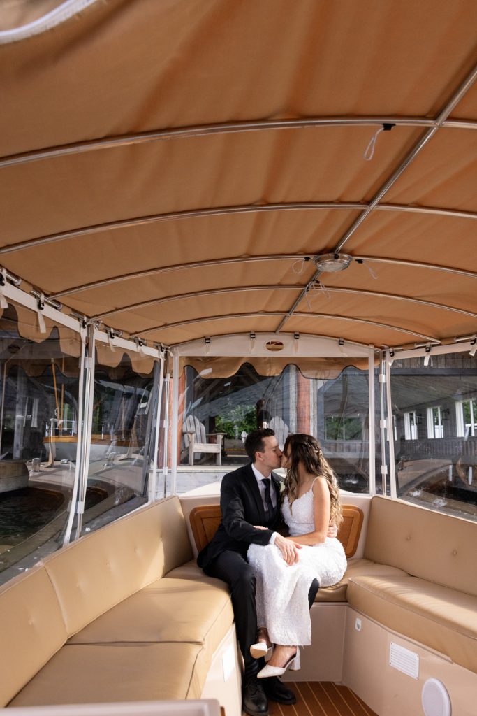 Brittany and Cole sharing a kiss on a boat transfer at Stout’s Island wedding in