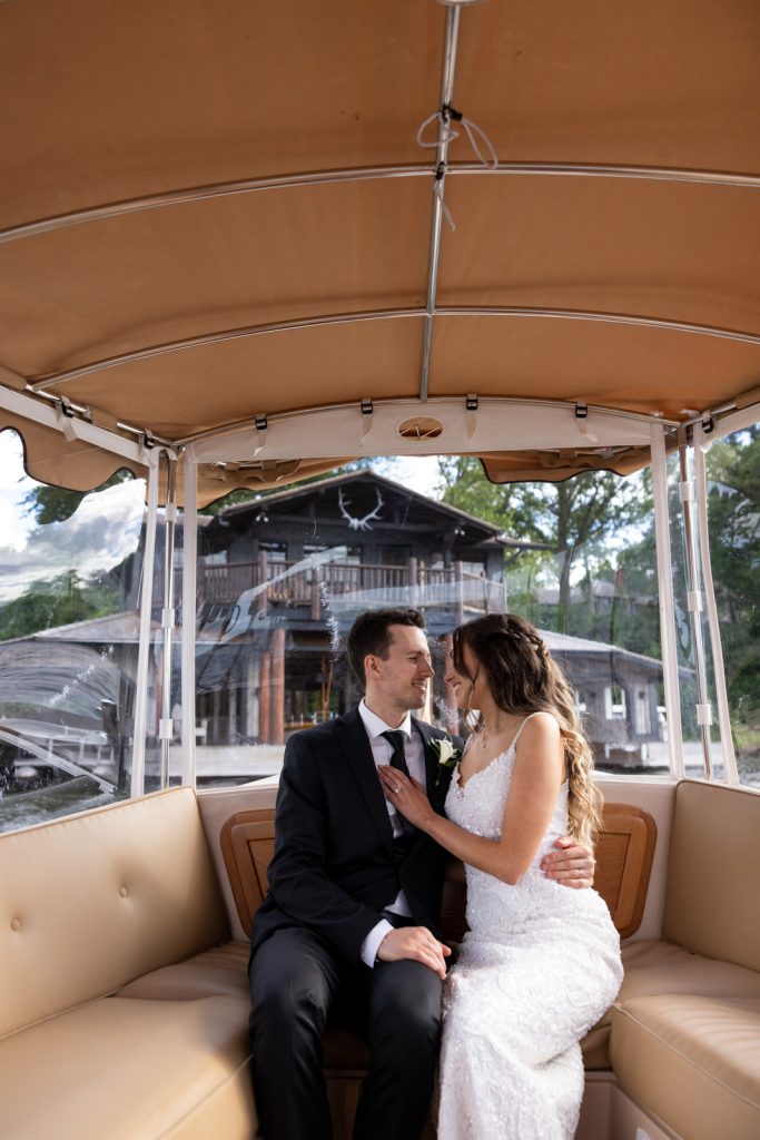 Brittany and Cole embracing in golf cart on Stout’s Island, Wisconsin wedding.