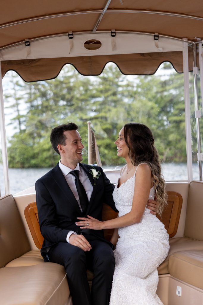 Brittany and Cole, the wedding couple, smiling and embracing on Stout’s Island boat transfer.
