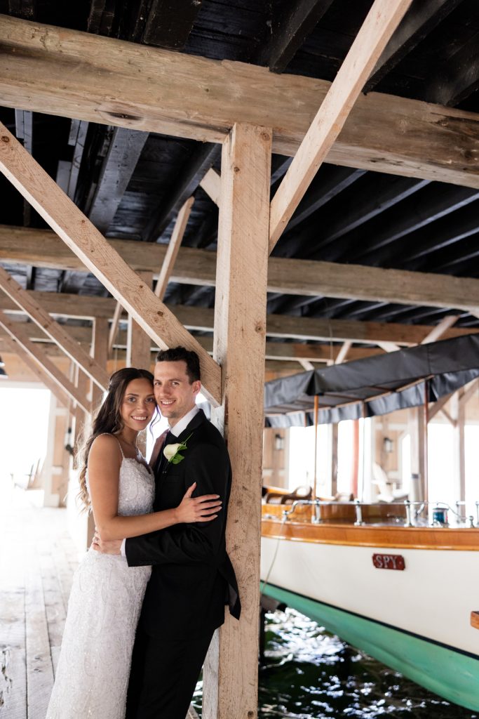 Brittany and Cole, the wedding couple, embracing under the boat house at Stout’s Island, Wisconsin.