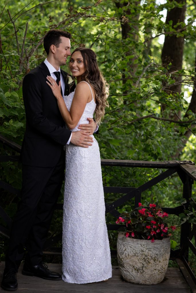 Brittany and Cole embracing on Stout’s Island wedding day, surrounded by lush greenery and a