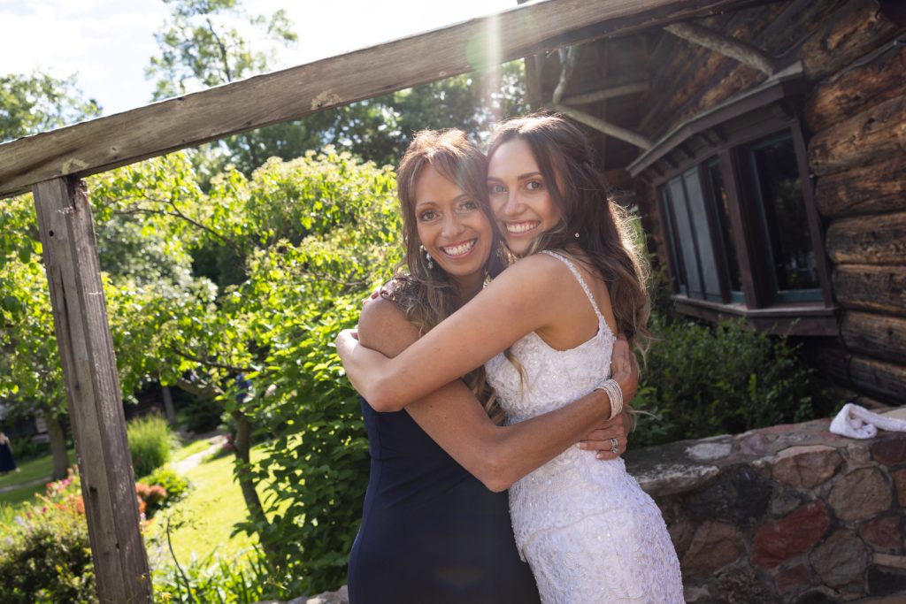 Bride in wedding dress embracing a guest at Stout’s Island wedding in Wisconsin.