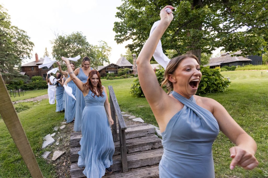 Bridesmaids waving white handkerchiefs celebrating Brittany and Cole's Stout’s Island wedding in Birchwood, Wisconsin.