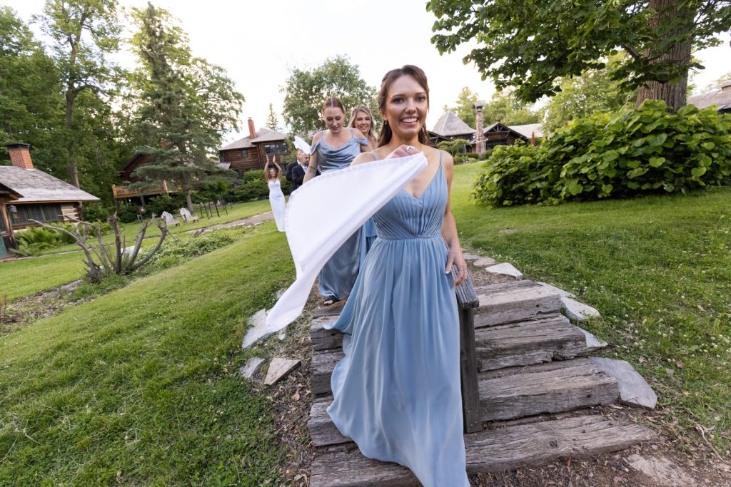 Bride and bridesmaids walking on stone path at Stout’s Island wedding in Birchwood, Wisconsin.