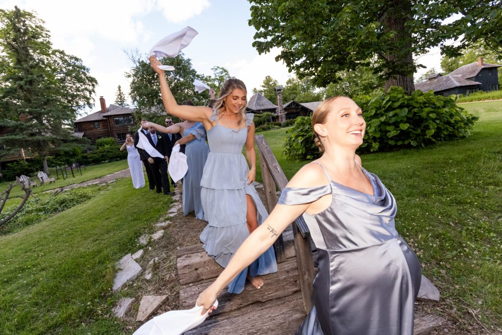 Brittany and Cole's wedding party walking on a bridge at Stout’s Island in Birchwood, Wisconsin.