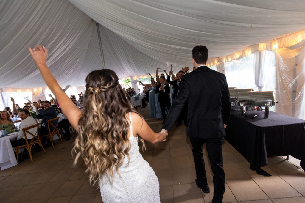 Brittany and Cole wedding reception at Stout’s Island, Birchwood, Wisconsin, couple walking through tent with