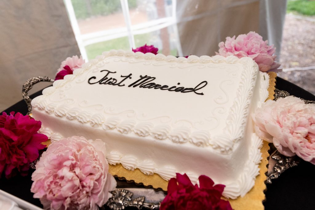 Wedding cake with "Just Married" inscription and pink flowers at Stout’s Island wedding in Wisconsin.