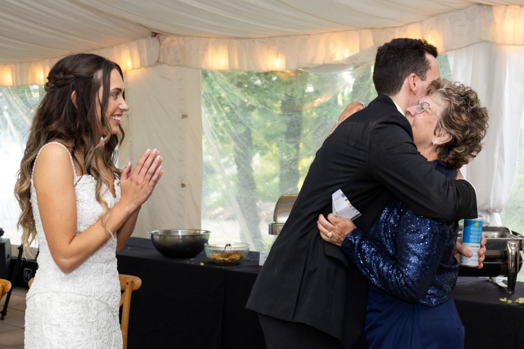 Brittany the bride hugging her mother at Stout’s Island wedding reception.