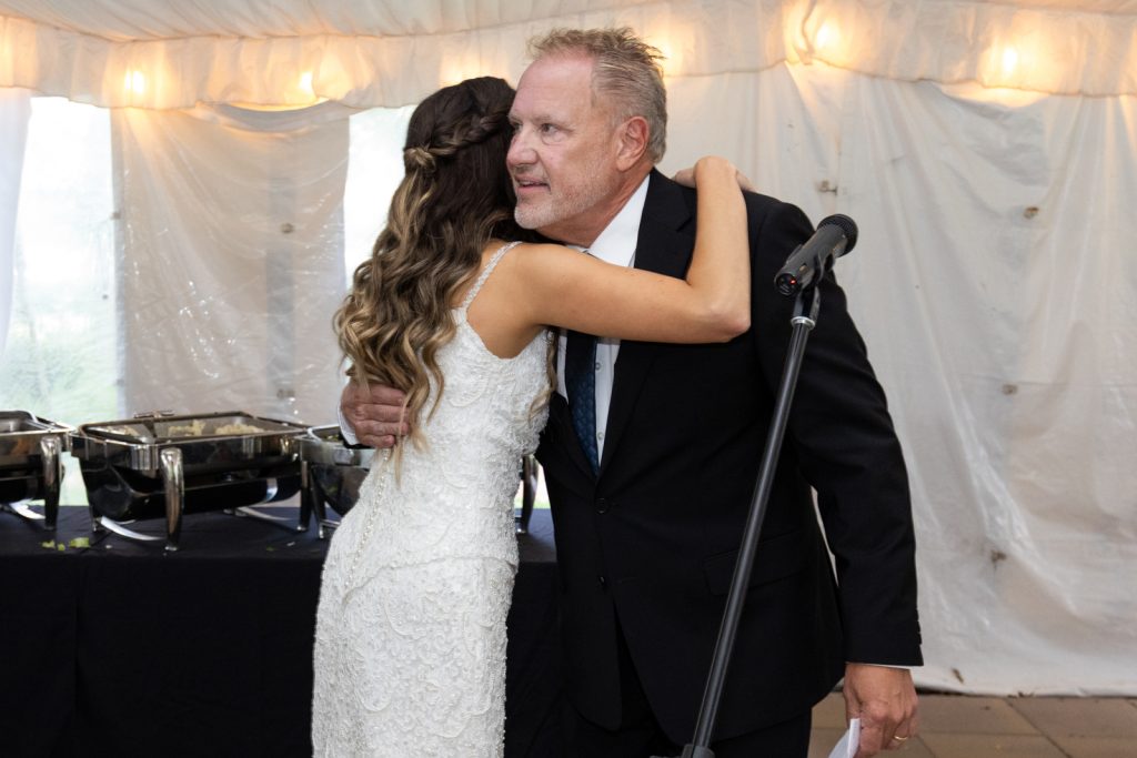 Bride embracing father at Stout’s Island wedding reception, Birchwood, Wisconsin.