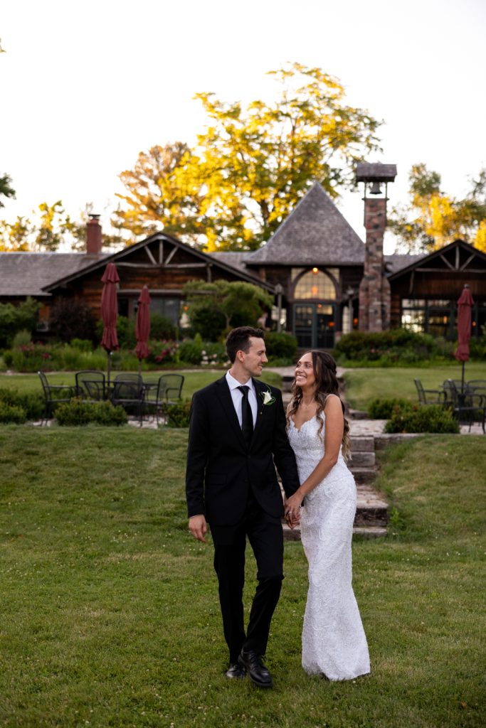 Brittany and Cole, the happy couple, holding hands at their Stout’s Island wedding in Birchwood,