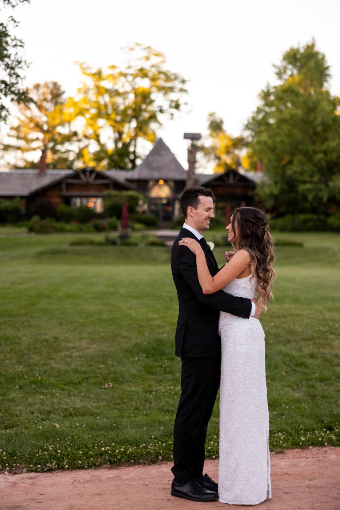 Brittany and Cole embracing at Stout’s Island wedding reception in Birchwood, Wisconsin, with the lodge