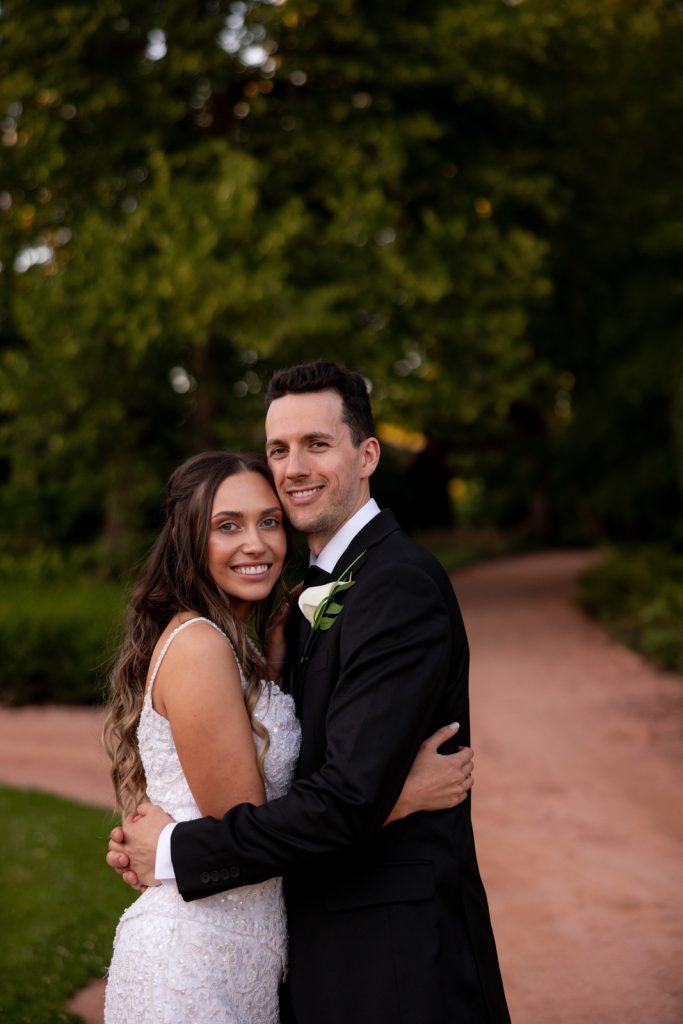 Brittany and Cole, the happy couple, embracing at their Stout’s Island wedding in Birchwood, Wisconsin.