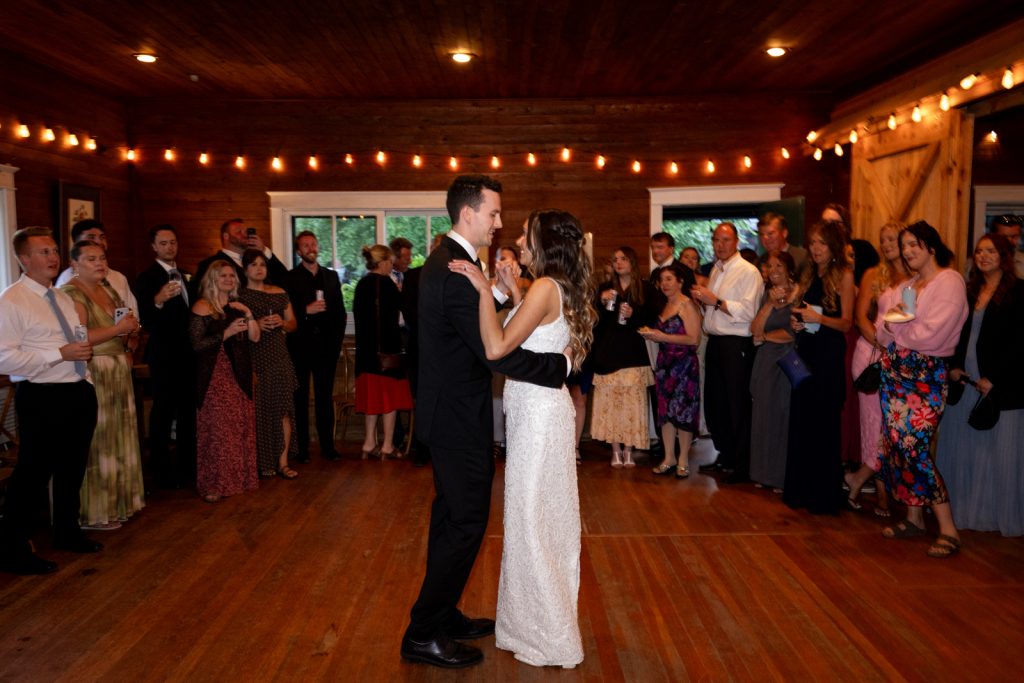 Brittany and Cole first dance at Stout’s Island wedding reception, surrounded by guests in Birchwood,