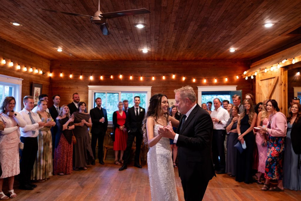 Brittany and Cole dancing at their Stout’s Island wedding reception, surrounded by guests and string