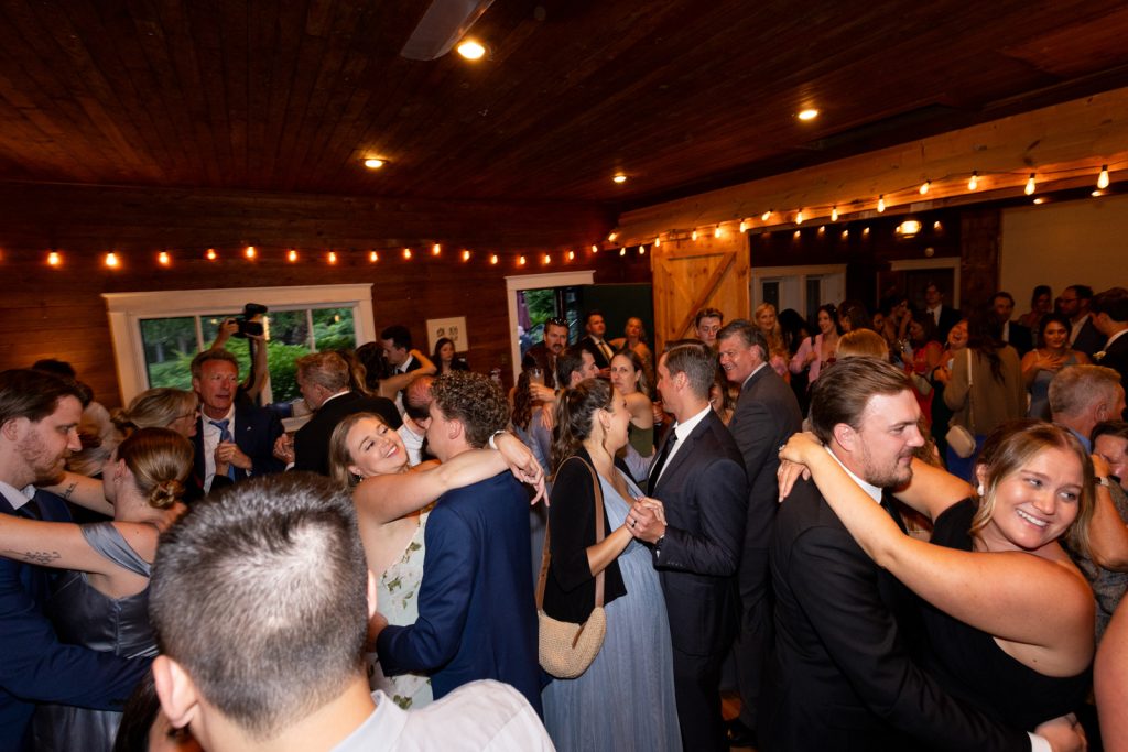 Brittany and Cole's wedding reception at Stout’s Island Lodge, Wisconsin, with guests dancing and celebrating.