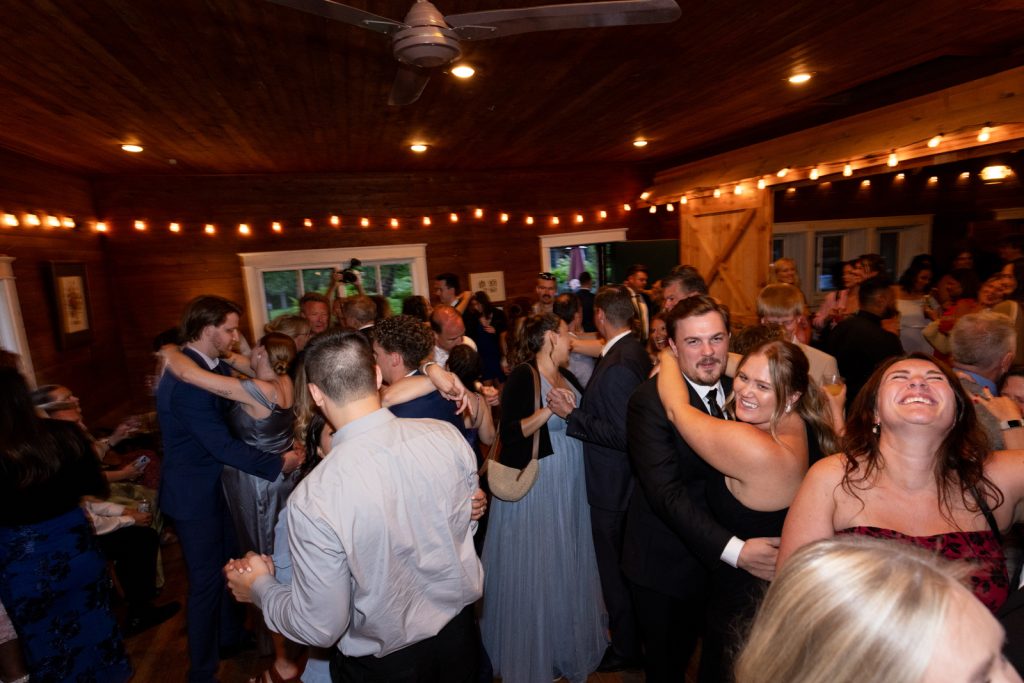 Wedding reception celebration at Stout’s Island Lodge, Birchwood, Wisconsin, with guests dancing and enjoying the
