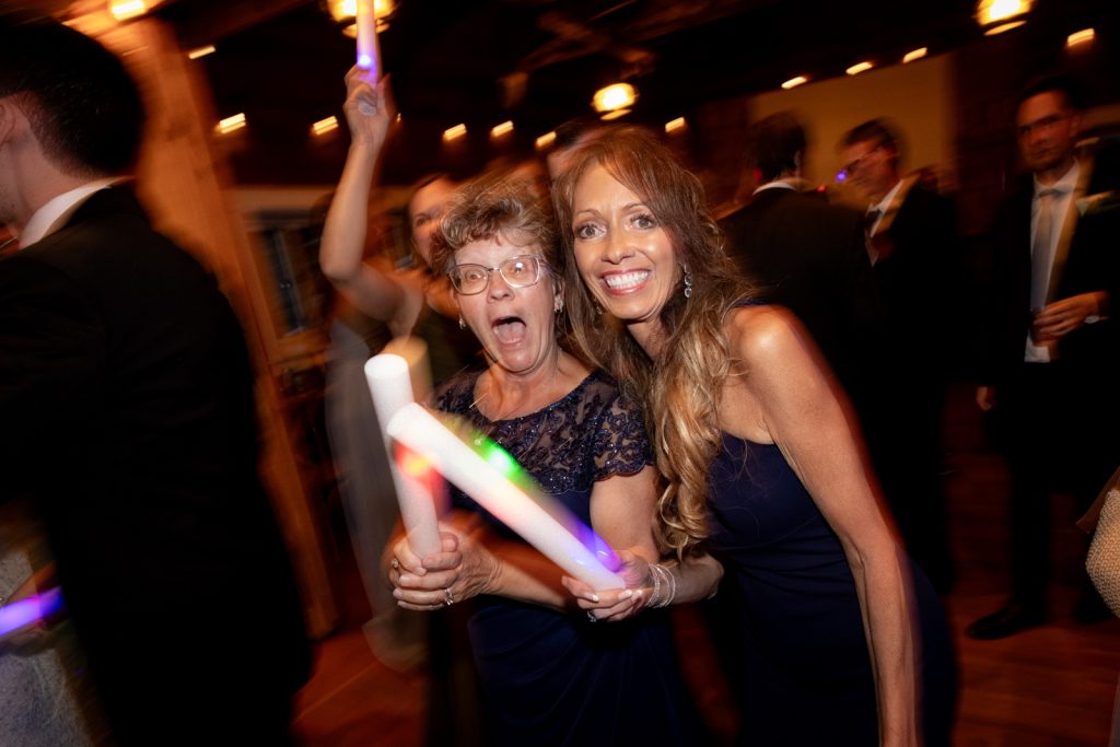Guests celebrating at a Stout’s Island wedding reception with glow sticks and smiles.