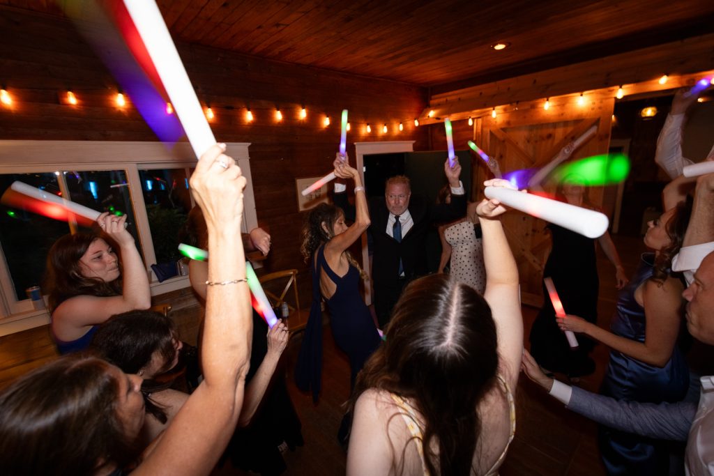 Wedding reception celebration with glow sticks and dancing at Stout’s Island Lodge.