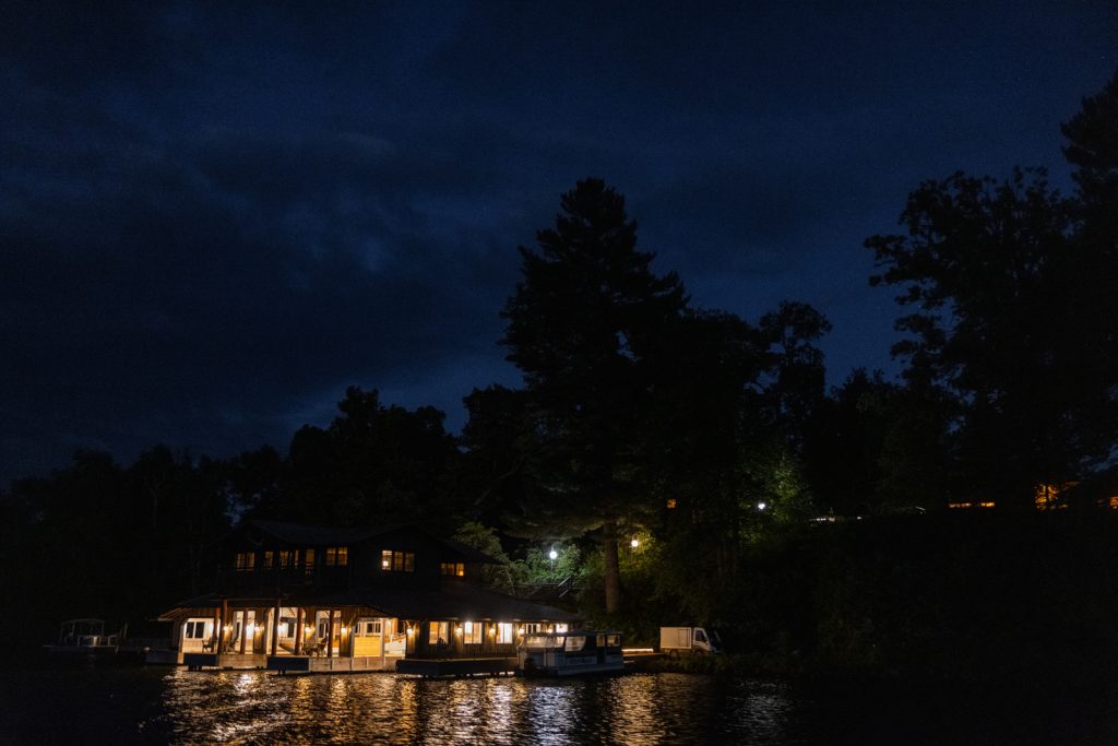 Stout’s Island Lodge at night, illuminated boat house and lake view, Wisconsin wedding photography.
