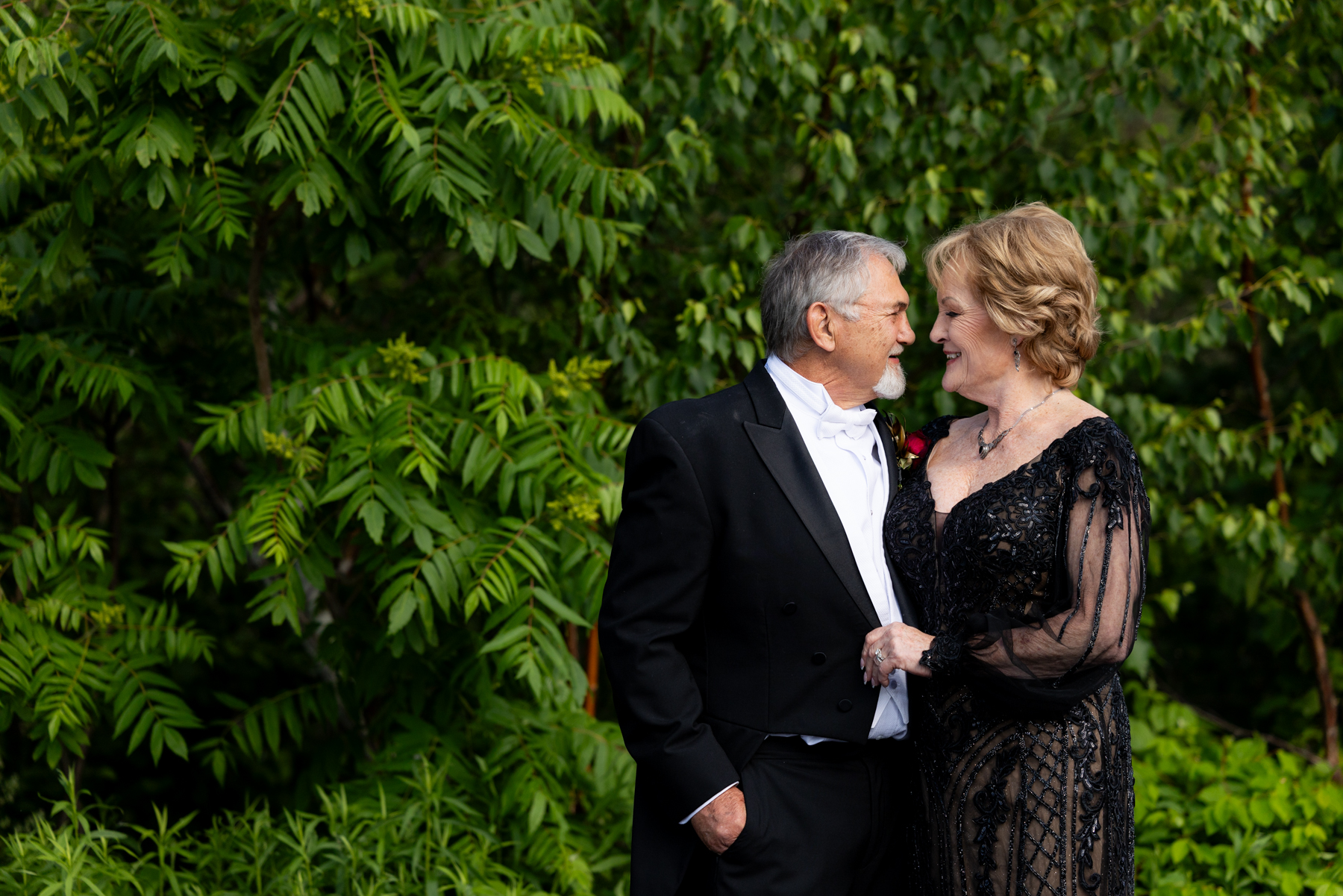 Bride and groom embracing in formal wear at a lakeside wedding in Hayward, Wisconsin.
