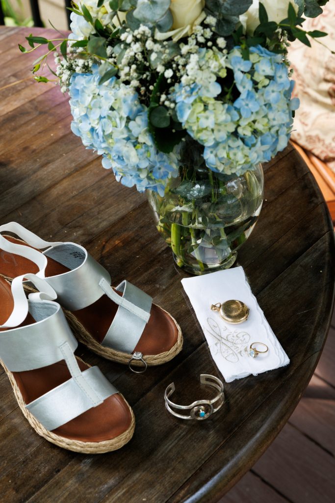 Blue hydrangeas and wedding details on a wooden table in Hayward, WI.