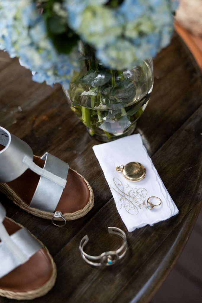 Bride's silver sandals, wedding rings, and jewelry detail from Hayward, WI wedding.