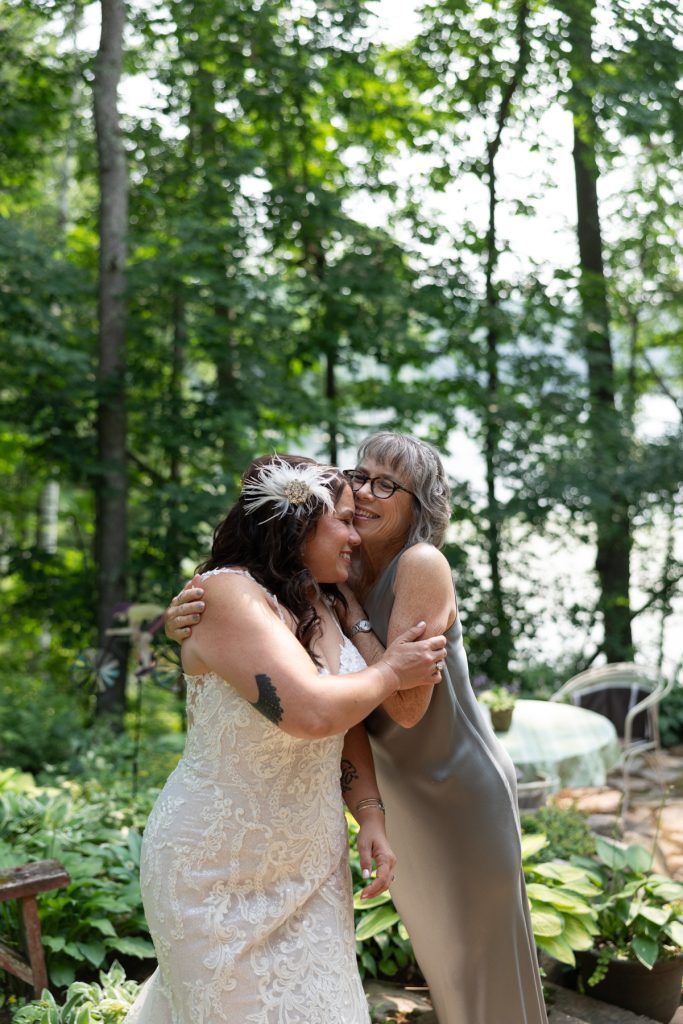 Bride and mother sharing a heartfelt moment at a lake wedding in Hayward, WI.