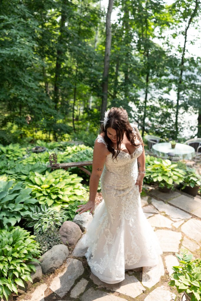 Bride in wedding dress on stone path overlooking lake at Hayward, WI wedding
