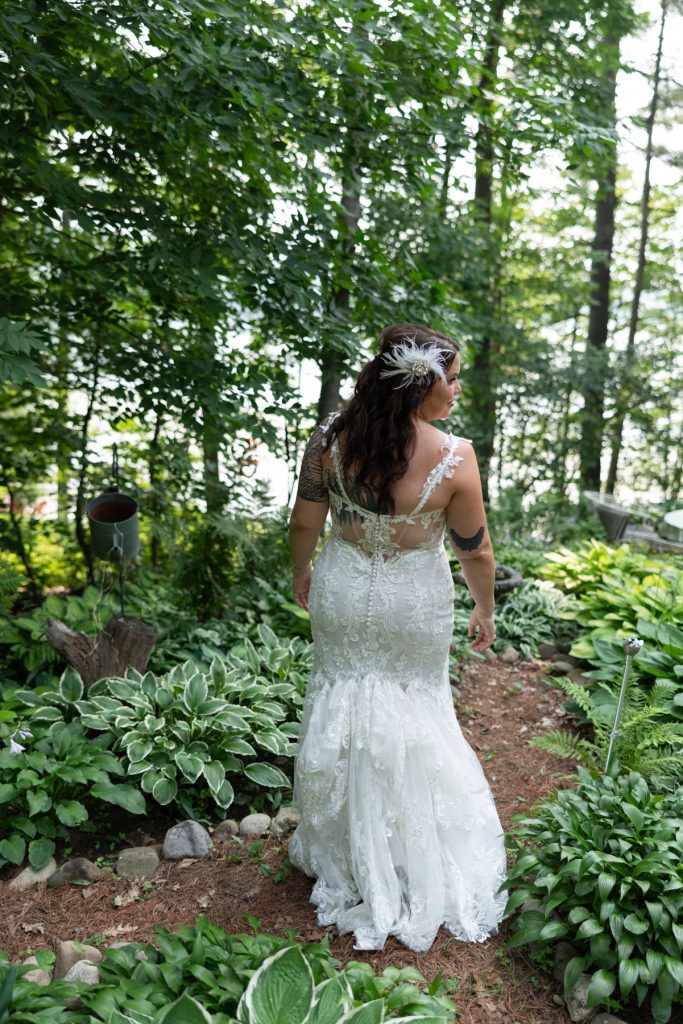 Bride in wedding dress walking through lakeside cabin garden in Hayward, WI