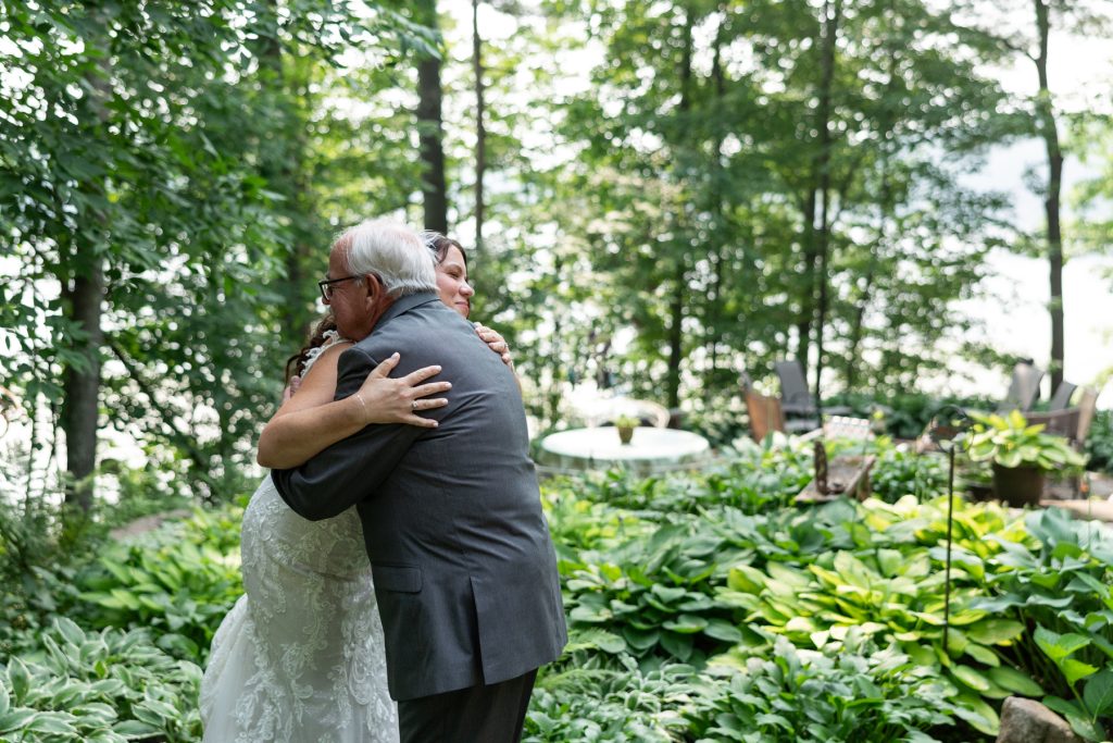 Bride embracing father at lake-side wedding in Hayward, WI