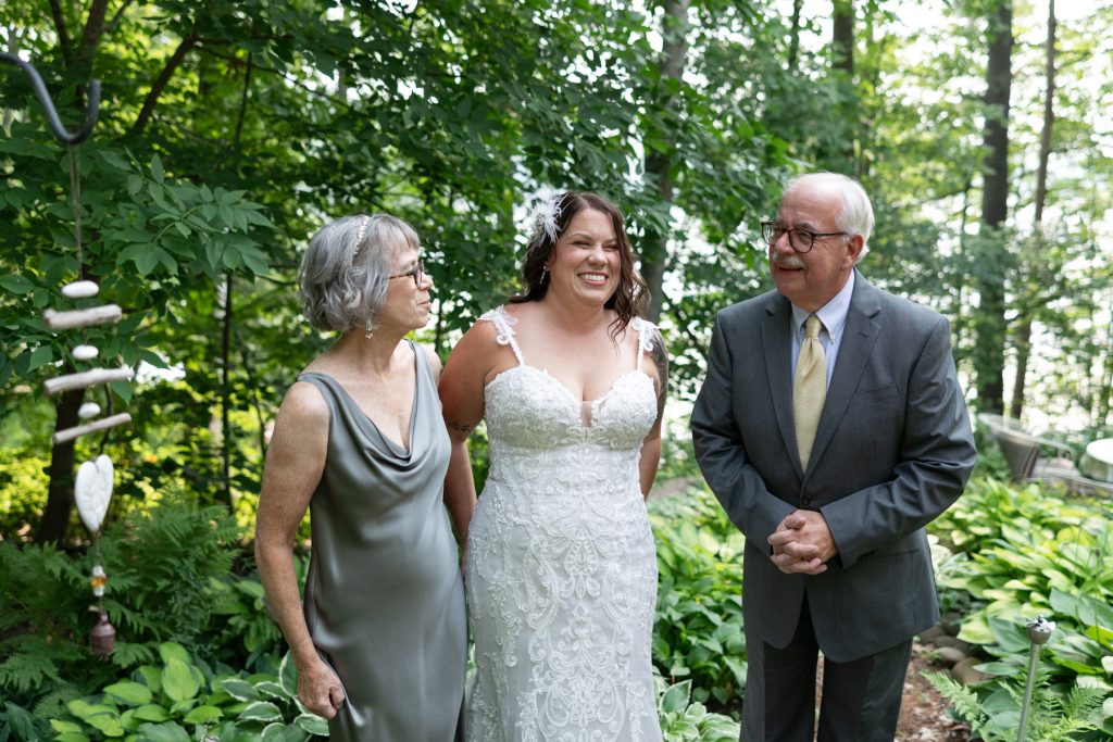 Bride with parents at Hayward, WI lake wedding ceremony.