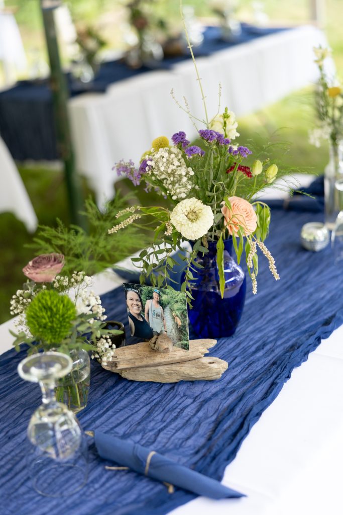Wedding table centerpiece with blue vase and flowers, framed photo of couple, Hayward WI wedding.