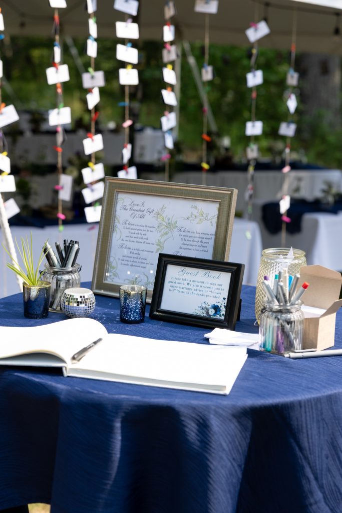 Guest book table with pens and framed cards at a lakeside wedding in Hayward, WI.