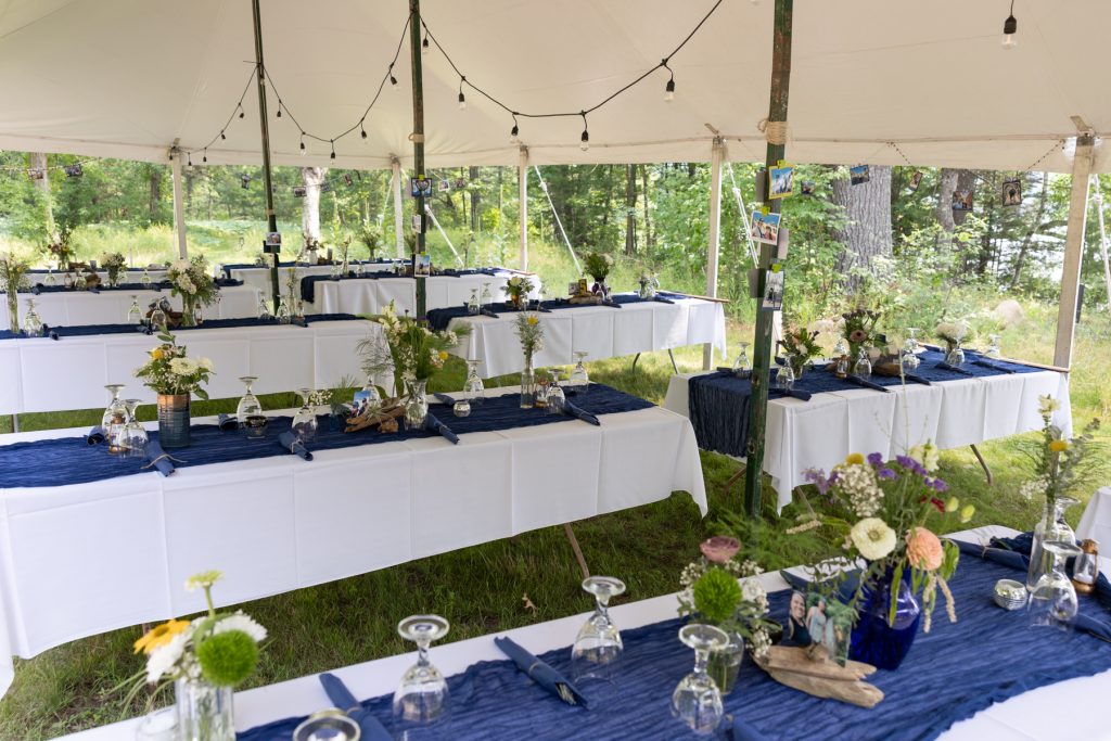 Wedding reception tables set up outdoors at a family cabin in Hayward, WI.
