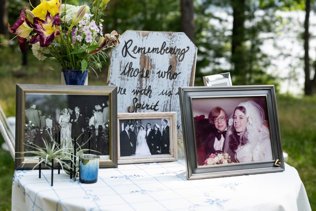 Rustic wooden sign and framed wedding photos at Hayward, WI lakeside wedding.