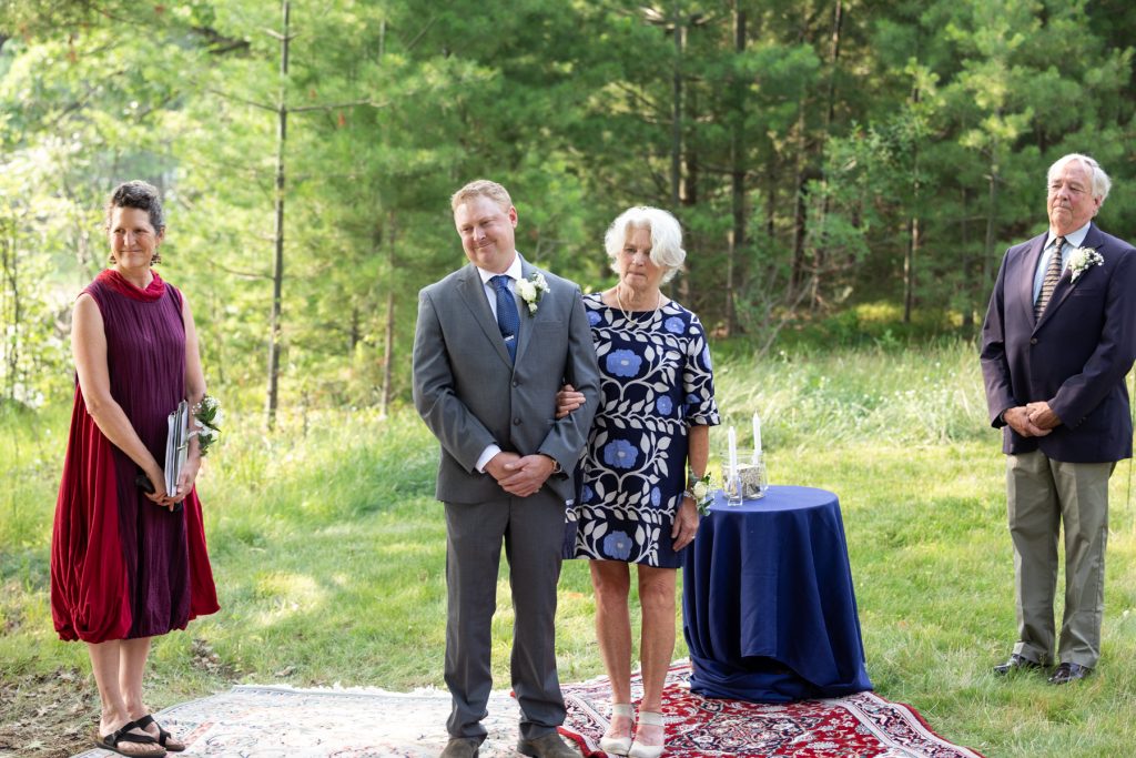 Bride and groom with parents at lakeside wedding ceremony in Hayward, WI