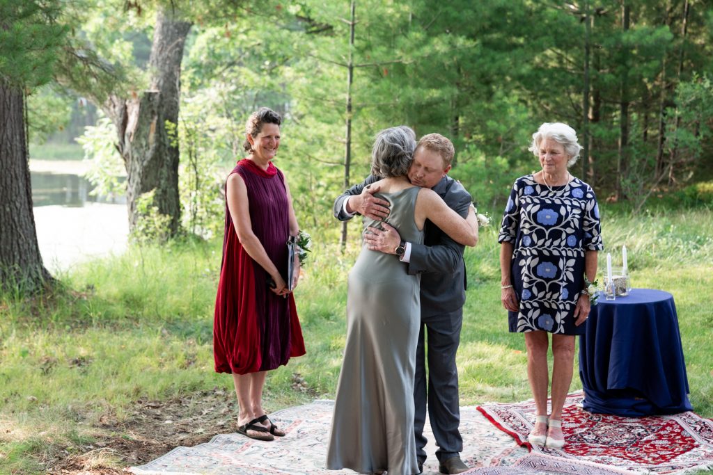 Bride and groom embracing at lakeside wedding in Hayward, WI.