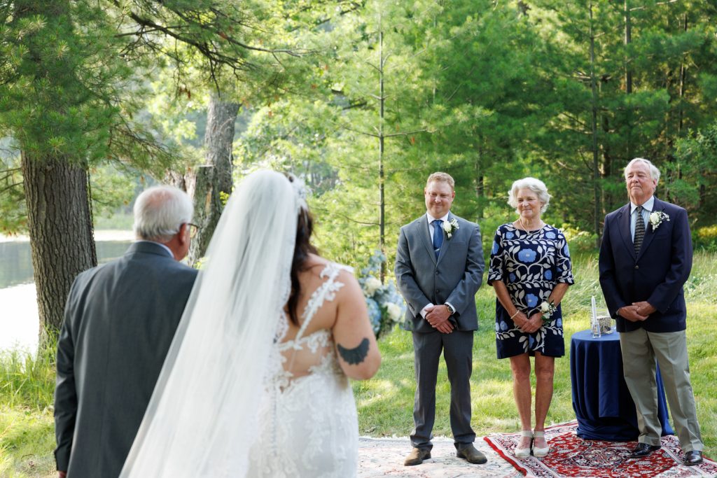 Bride and groom with family at lakeside wedding ceremony in Hayward, WI