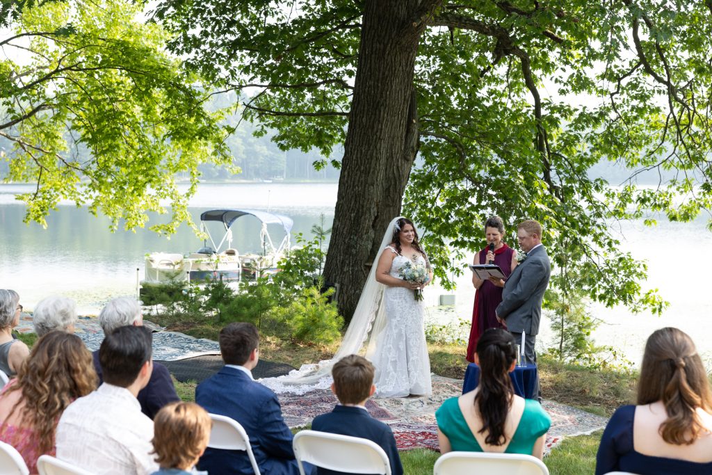 Bride and groom exchanging vows at lakeside wedding ceremony in Hayward, WI.