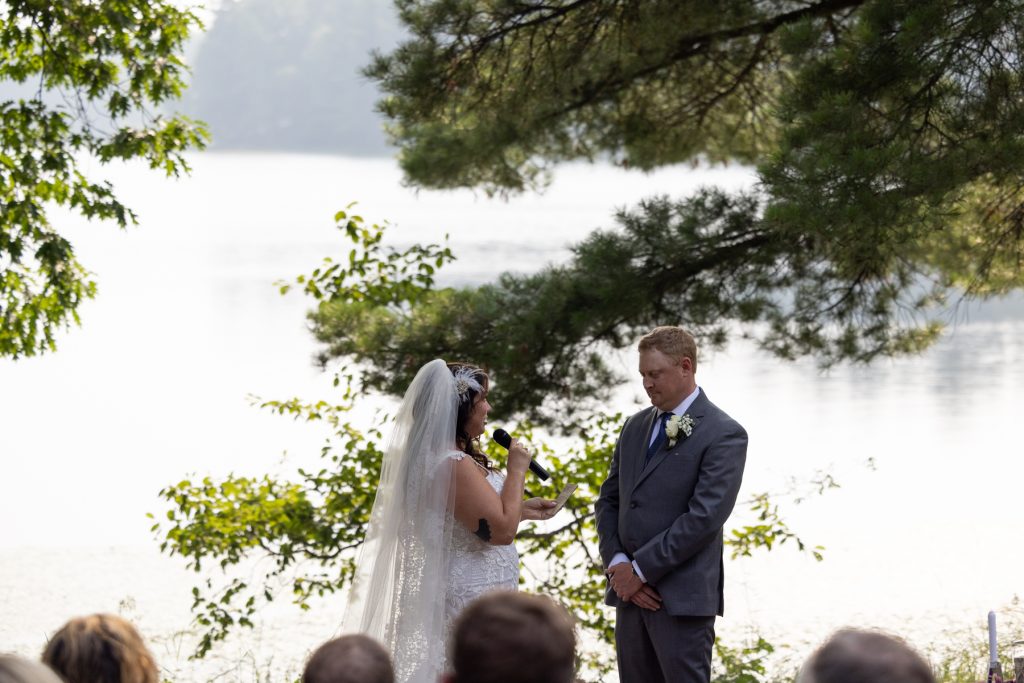 Bride and groom exchanging vows at lakeside wedding in Hayward, WI