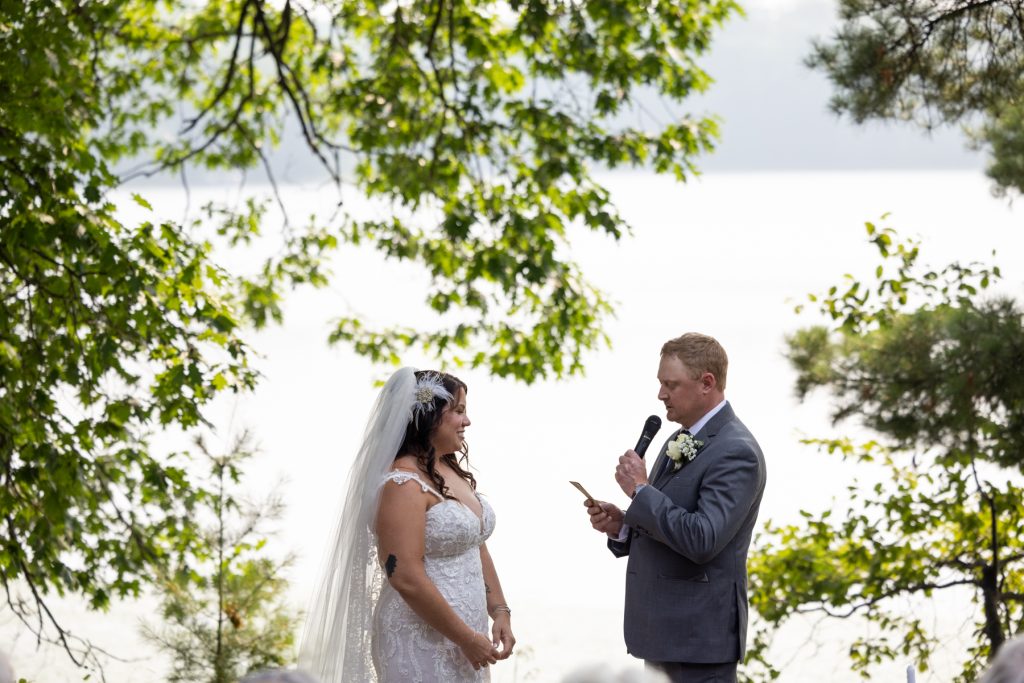 Bride and groom exchanging vows at lake-side wedding in Hayward, WI.