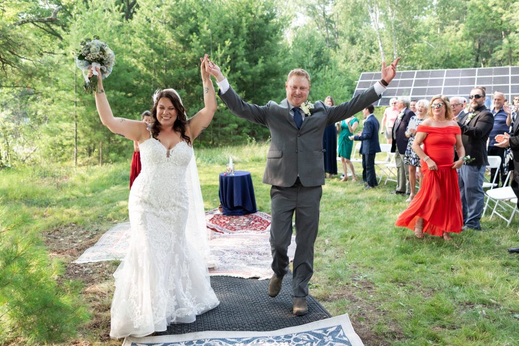 Bride and groom celebrating at backyard wedding in Hayward, WI, overlooking the lake.