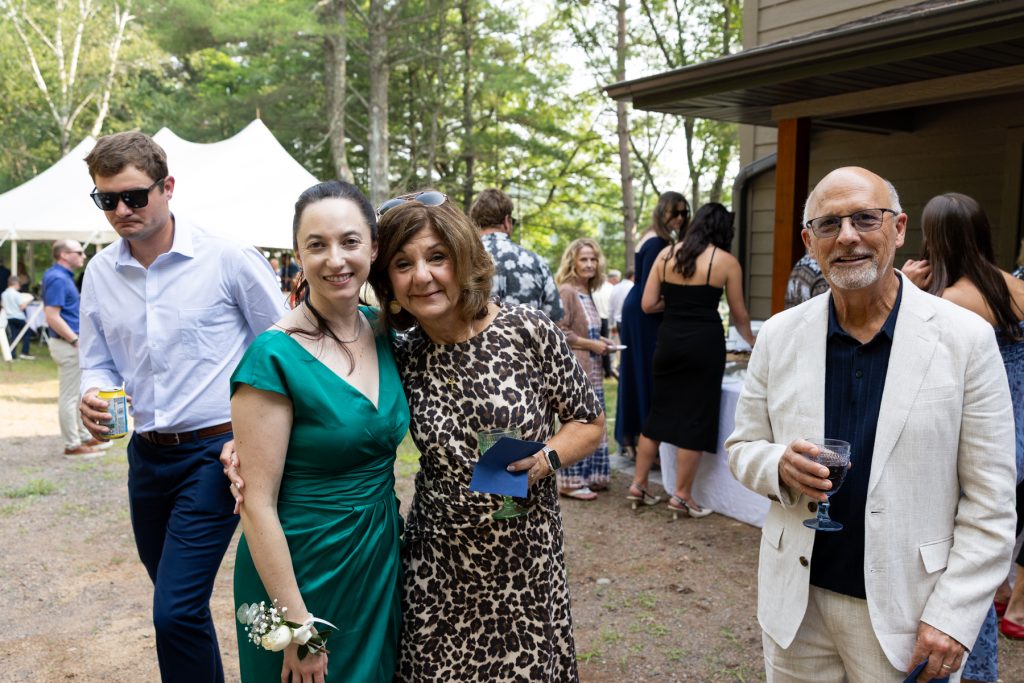 Wedding guests smiling and posing at a lakeside cabin in Hayward, WI.