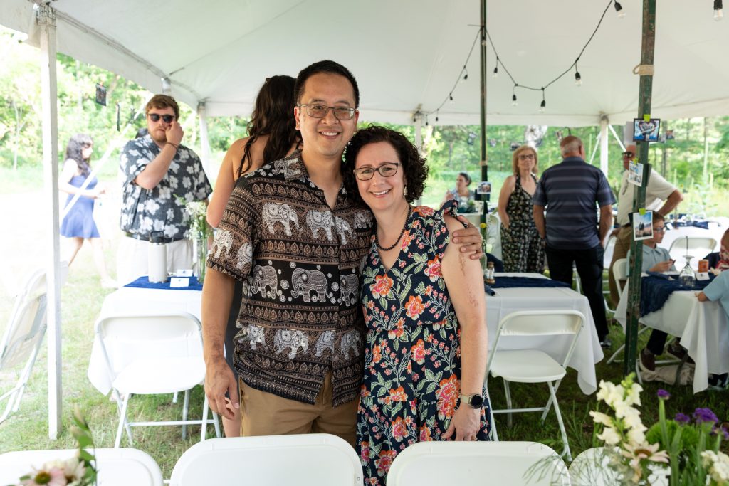 Couple smiling at a wedding reception in Hayward, WI, under a white tent.