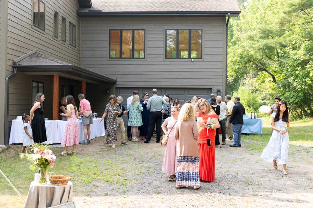 Wedding guests gathered at a lakeside cabin in Hayward, WI, celebrating Emma and Peter's backyard