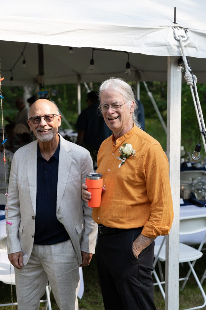 Groom's father and guest smiling at a wedding in Hayward, WI.