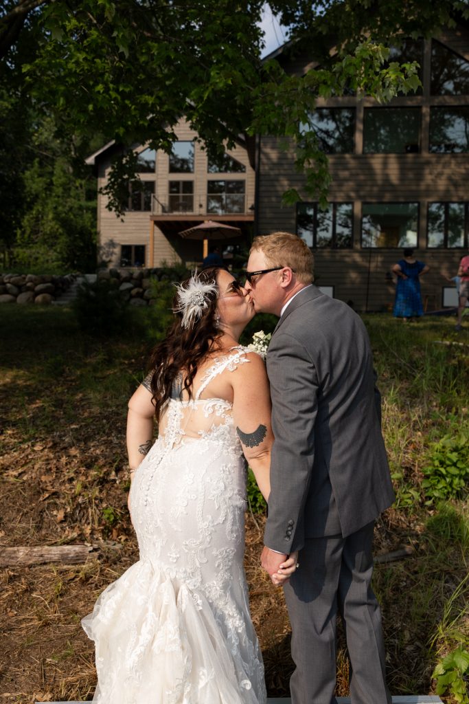 Bride and groom kissing at lakefront wedding in Hayward, WI