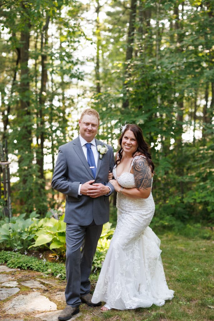Bride and groom posing at lakeside cabin wedding in Hayward, WI