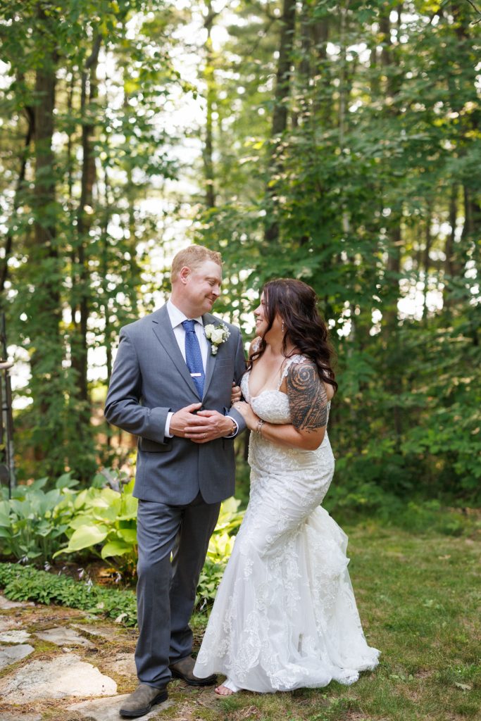 Bride and groom embracing at a lakeside cabin wedding in Hayward, WI.