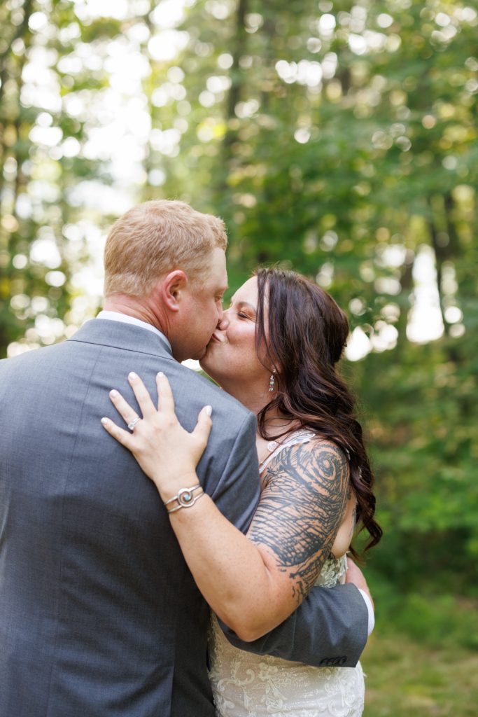 Bride and groom kissing at a lakeside wedding in Hayward, WI
